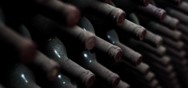 bouteilles de vins poussièreuses rangés dans une cave
