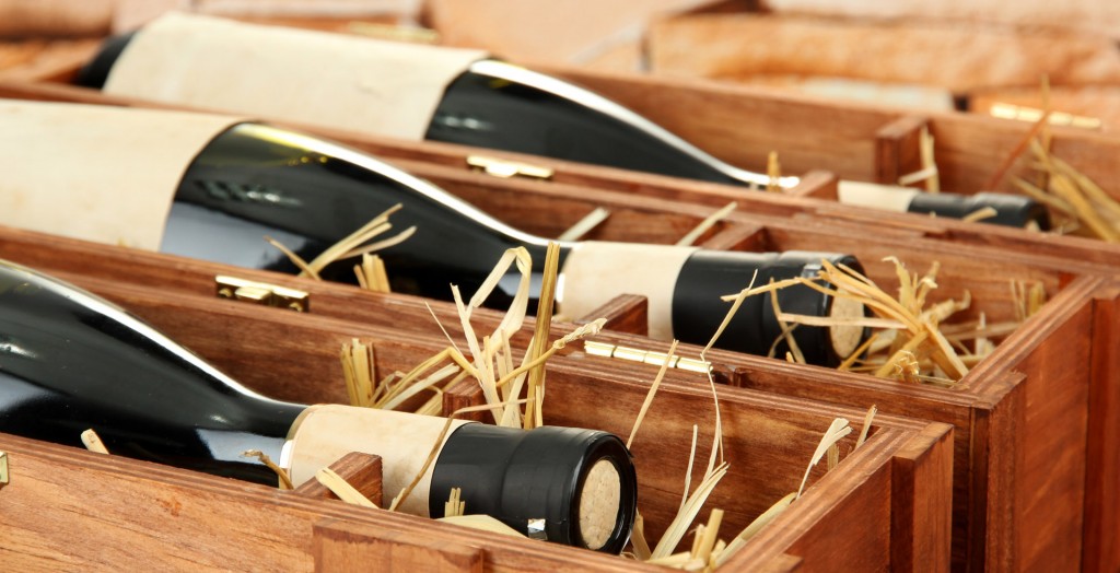bouteilles de vins dans des coffrets bois avec de la paille en guise de support intérieur